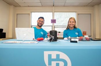 Man and woman smiling and working at a the event table